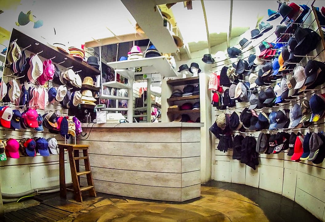 Salón con el mostrador y la pared de gorras